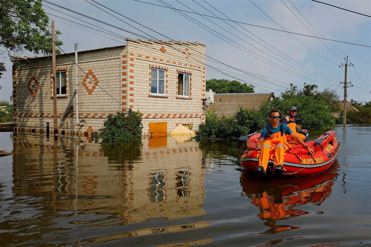 <i>Alexander Ermochenko/Reuters</i><br/>Members of Russia's emergencies ministry use an inflatable boat in a flooded area following the collapse of the Kakhovka dam on June 8.