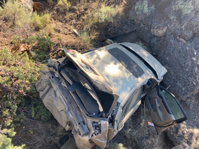 Caller informed Crook County 911 of crashed SUV in creek bed at bottom of embankment off Juniper Canyon Road