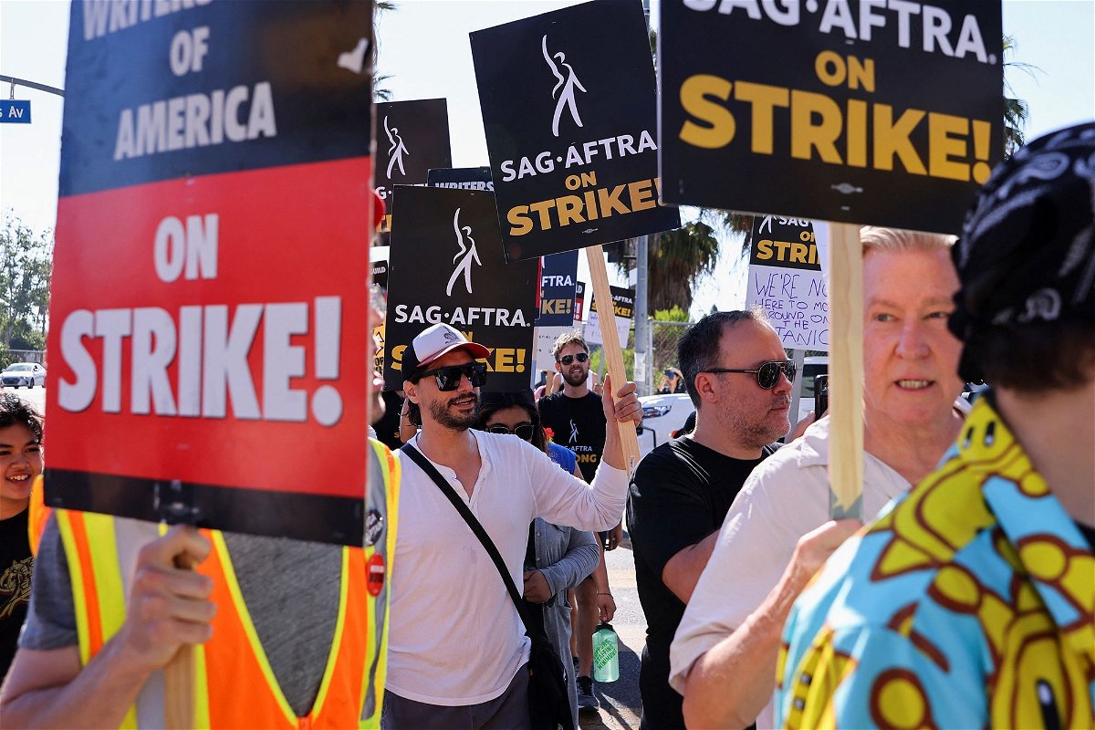 <i>Mike Blake/Reuters</i><br/>SAG-AFTRA actors strike against the Hollywood studios as they join the Writers Guild of America (WGA) on the picket like outside of Netflix offices in Los Angeles