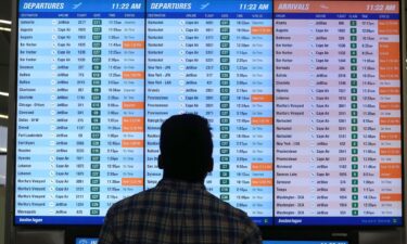 A man views a flight board at Boston Logan International Airport