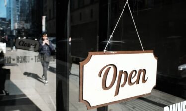 A store displays an 'open' sign along a street in Manhattan on February 14