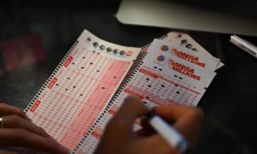 A person plays lottery at a store as US Powerball jackpot grand prize grew to a whopping $1 billion after no ticket got all six numbers in San Mateo
