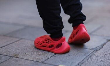 A fashion week guest seen wearing red Adidas Yeezy shoes during London Fashion Week in September 2022.