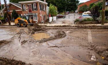 Workers remove mud from Main street after heavy rains in Highland Falls