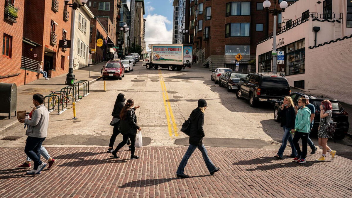 <i>David Ryder/Getty Images</i><br/>Pedestrians cross the street in Seattle