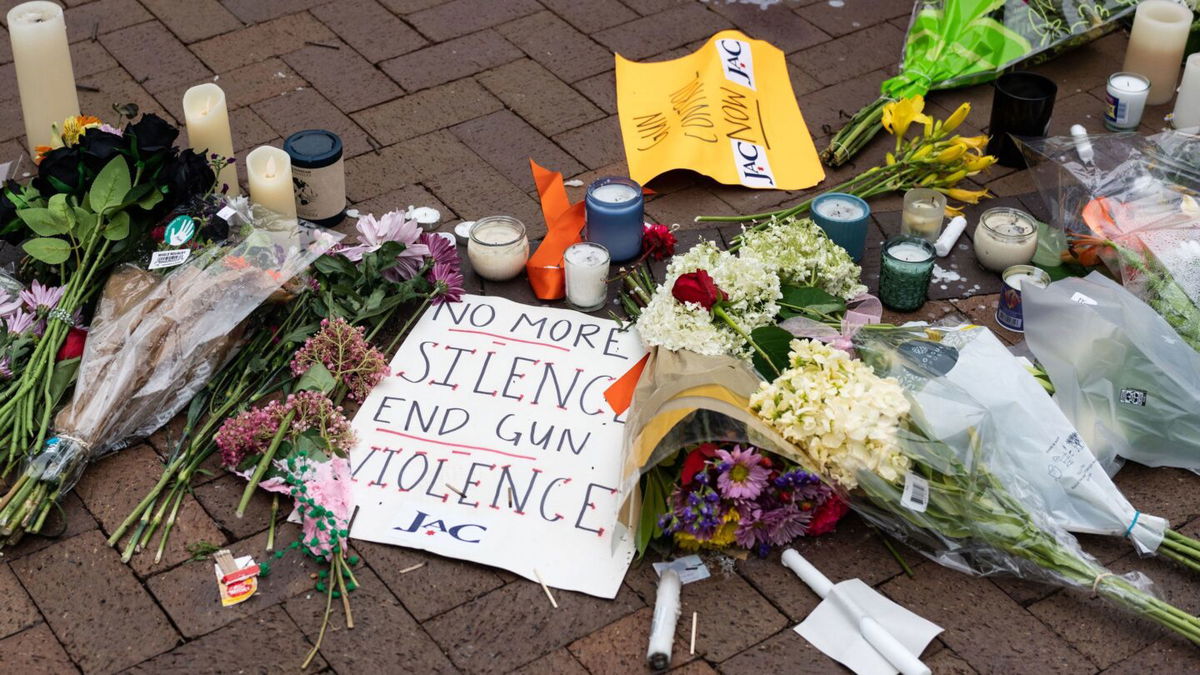 <i>Max Herman/AFP/Getty Images</i><br/>Signs and flowers are pictured at a makeshift memorial for victims of the 4th of July mass shooting in downtown Highland Park