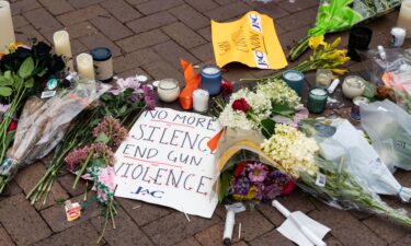 Signs and flowers are pictured at a makeshift memorial for victims of the 4th of July mass shooting in downtown Highland Park