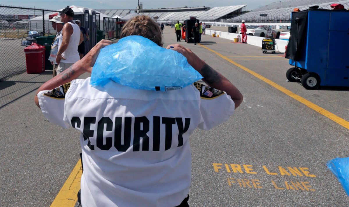 <i>Charles Krupa/AP</i><br/>Track security officer Patty Patterson carries a bag of ice on her shoulders as she walks back to her post during a NASCAR Cup Series auto race practice at New Hampshire Motor Speedway in Loudon