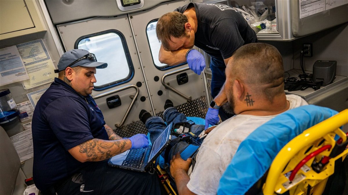 <i>Brandon Bell/Getty Images</i><br/>Emergency Medical Technicians William Dorsey and Omar Amezcua assist a person after he called in for chest pain on June 29