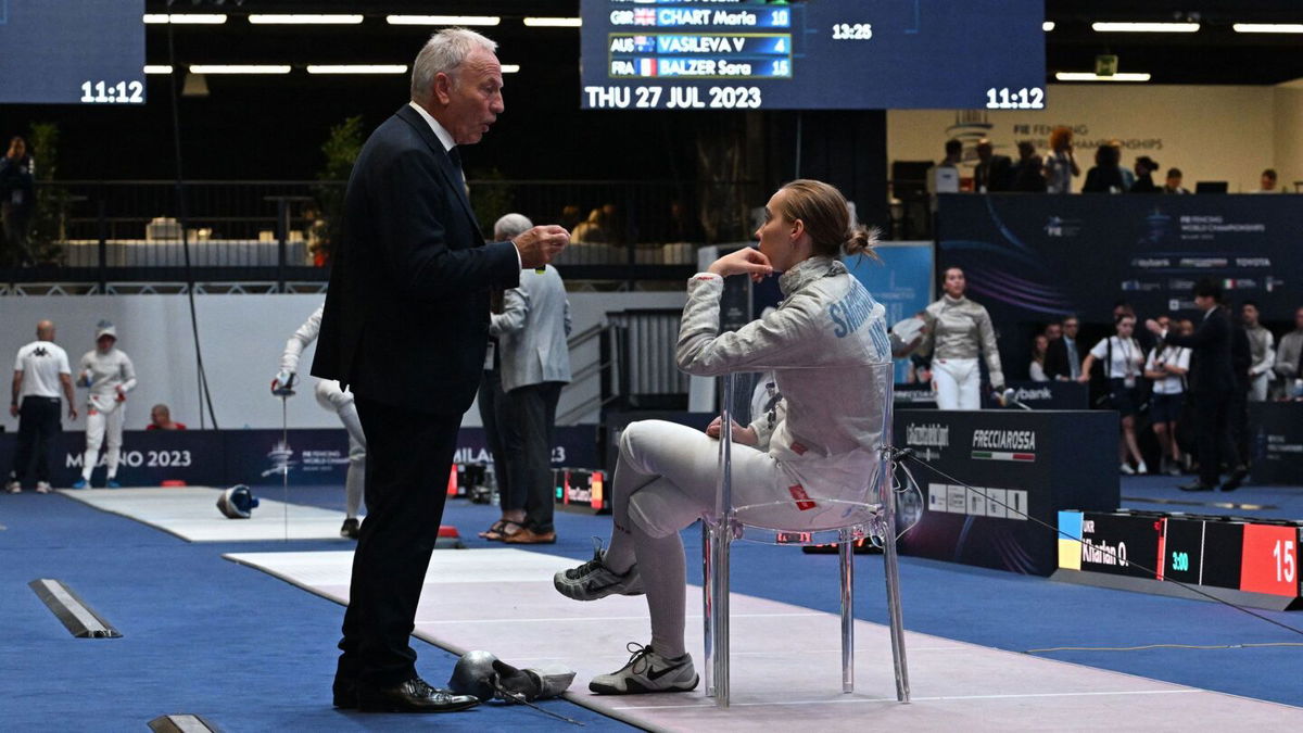 <i>Andreas Solaro/AFP via Getty Images</i><br/>An official of the International Fencing Federation (FIE) speaks Smirnova as she sits on the fencing strip.