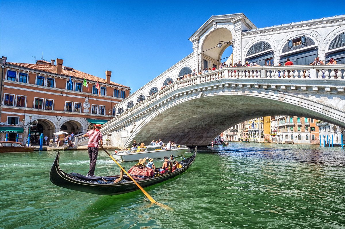 <i>Eloi_Omella/iStock Unreleased/Getty Images</i><br/>A gondola packed with tourists goes under the Rialto Bridge on the Grand Canal in Venice.