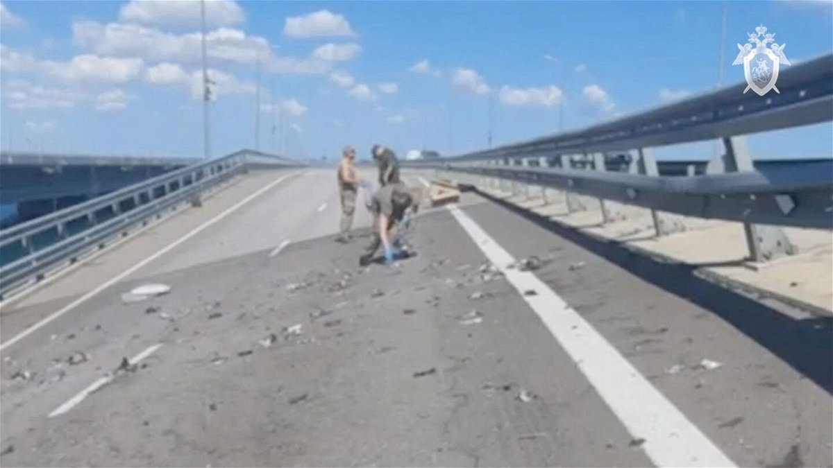 <i>Investigative Committee of Russia/Reuters</i><br/>Russian investigators work at the scene on the section of the bridge damaged on July 17.
