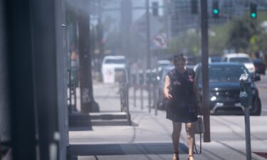 A person walks along Roosevelt Row in Phoenix on July 5. High temperatures there could stay north of 110 degrees through this week.