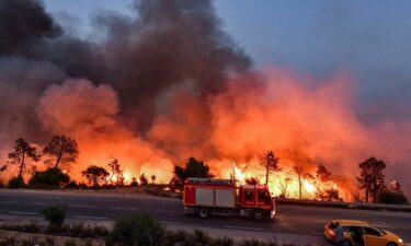 A fire truck moves along a road as a forest fire rages near the town of Melloula in northwestern Tunisia on July 24.