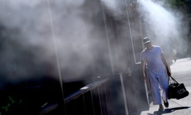 A man cools off under misters in Phoenix on July 14