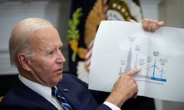 President Joe Biden points to a wind turbine size comparison chart during a meeting at the White House in June 2022. Sweeping climate commitments is an important goal for Biden.
