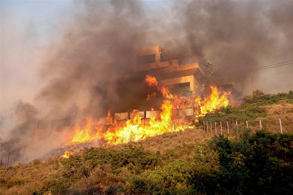 <i>Stelios Misinas/Reuters</i><br/>Flames engulf a house as a wildfire burns in Saronida