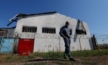 A security guard stands in front of the building in the settlement of Olenivka in the Donetsk Region