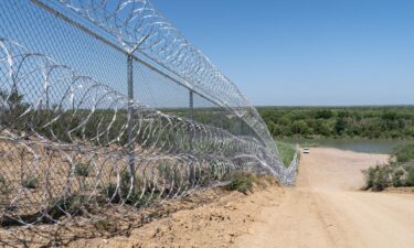 A razor wire fence runs alongside the Rio Grande River in Eagle Pass