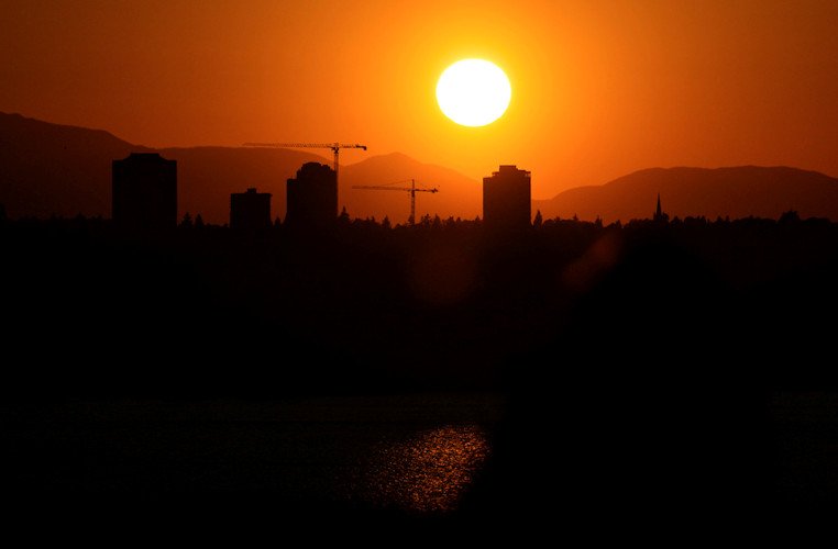The sun sets over the University District in Seattle, May 13, 2023, seen from 520 Bridge View Park in Medina, Wash.