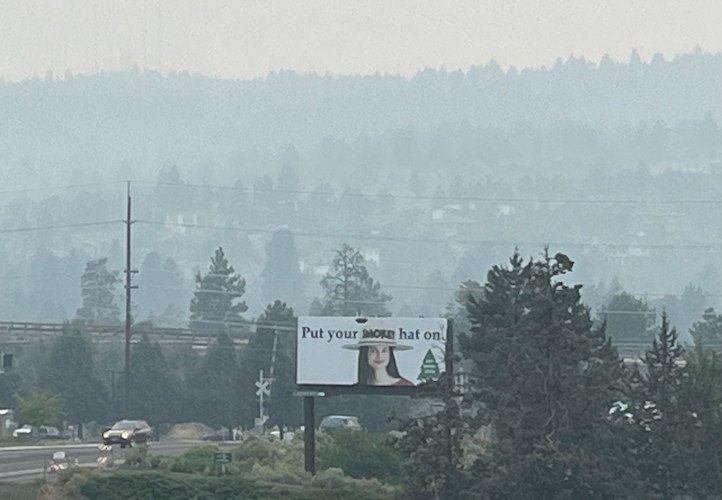 The 'Put Your Smokey Hat On' public awareness campaign has a bit of a different meaning on another smoky Monday morning in Bend