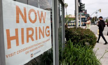 Job openings fell for the third consecutive month. Displayed is a 'Now Hiring' sign outside a resale clothing shop on June 2