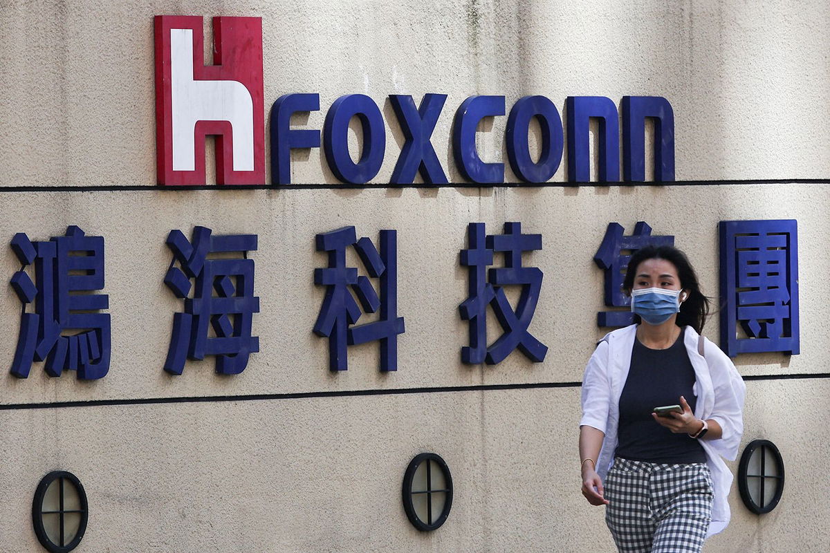 <i>Ann Wang/Reuters/File</i><br/>A woman walks past the logo of Foxconn outside the company's building in Taipei