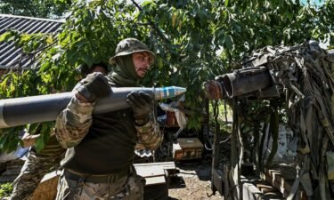 Ukrainian servicemen load a shell into a multiple rocket launch system before firing toward Russian troops at a position near a front line