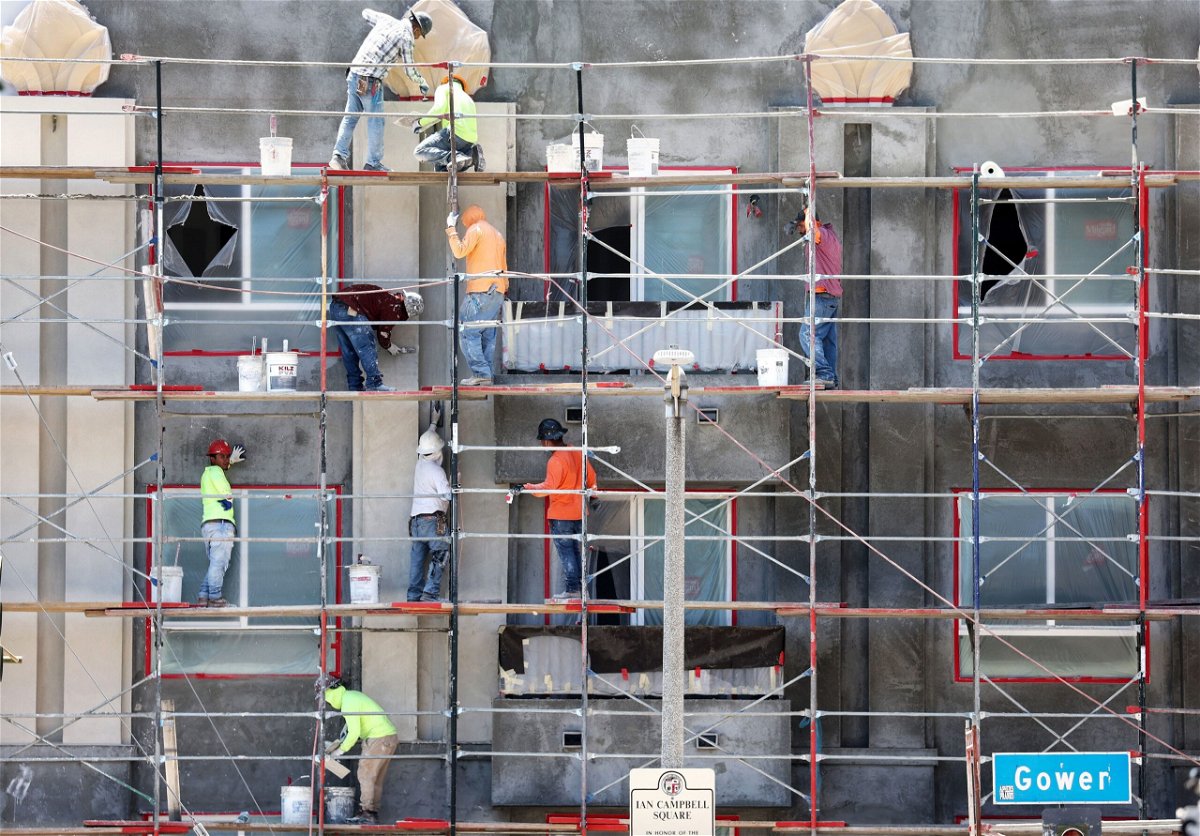 <i>Mario Tama/Getty Images</i><br/>Construction workers stand on scaffolding while building residential housing on July 12 in Los Angeles