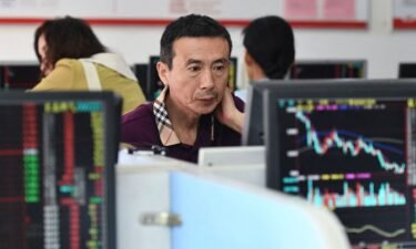 Investors monitor stock price movements at a securities company in Fuyang