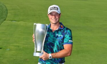 Viktor Hovland poses with the trophy after winning the BMW Championship at Olympia Fields Country Club in Illinois.