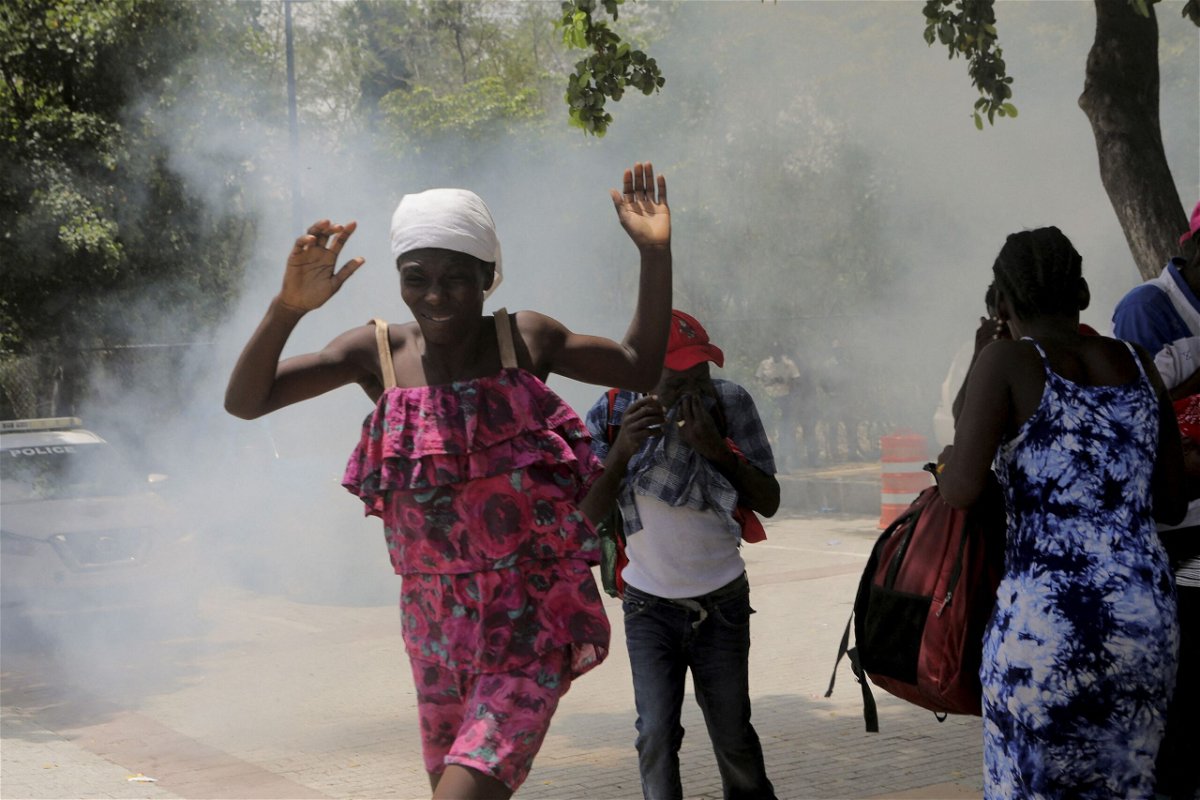 <i>Ralph Tedy Erol/Reuters</i><br/>Haitians flee tear gas fired by officers clearing a camp of people at the US embassy seeking to escape the violence of armed gangs on July 25.