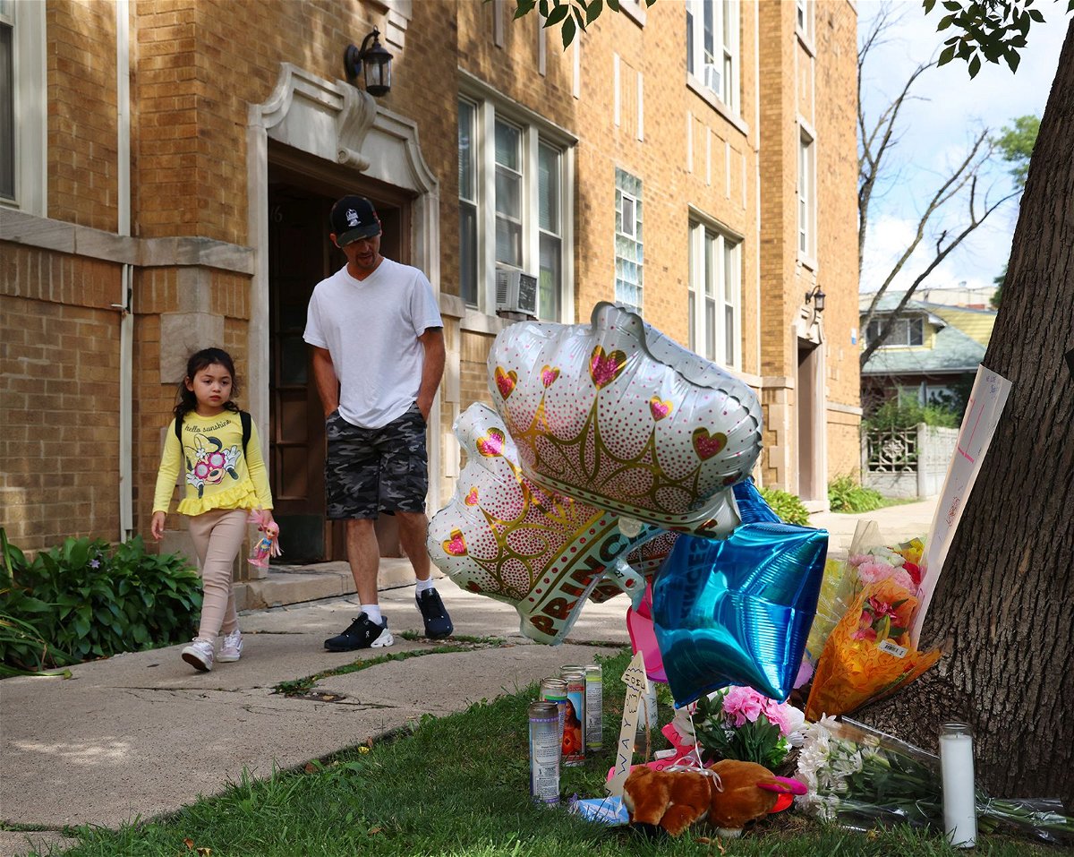 <i>Stacey Wescott/Chicago Tribune/TNS/Getty Images</i><br/>Neighbors pass by a memorial for a 9-year-old girl shot and killed outside of her Portage Park apartment on August 5 in Chicago.