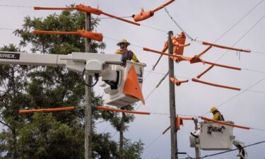 Workers secure power lines ahead of a storm.