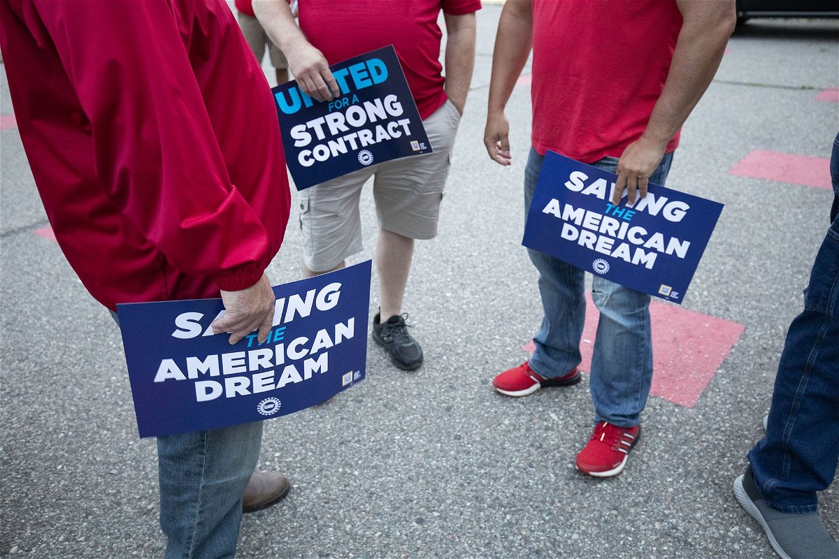 <i>Bill Pugliano/Getty Images</i><br/>Stellantis workers attend a rally with United Auto Workers president Shawn Fain to mark the beginning of the UAW's contract talks with Stellantis in July. The union announced on August 31 that it filed unfair labor practice charges against Stellantis and GM.