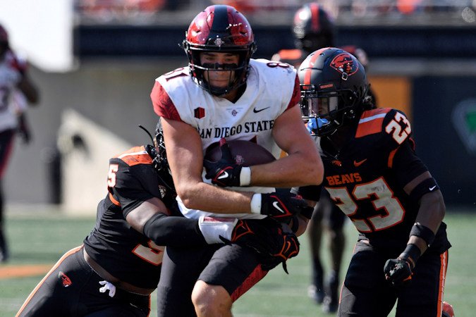 Oregon State linebacker Easton Mascarenas-Arnold (5) and defensive back Jermod McCoy (23) tackle San Diego State tight end Mark Redman (81) during the second half of Saturday's game in Corvallis
