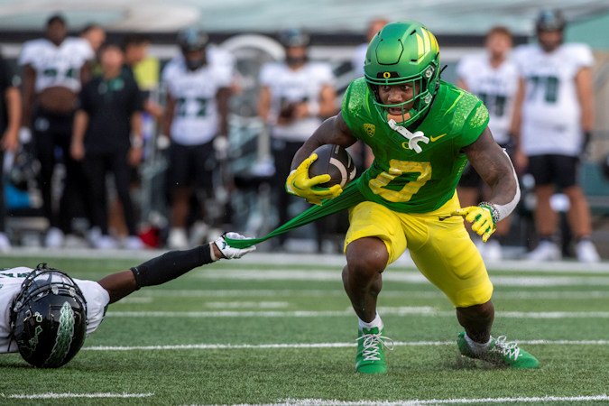 Hawaii defensive back Caleb Brown slows down Oregon running back Bucky Irving (0) during the first half of their contest Saturday in Eugene