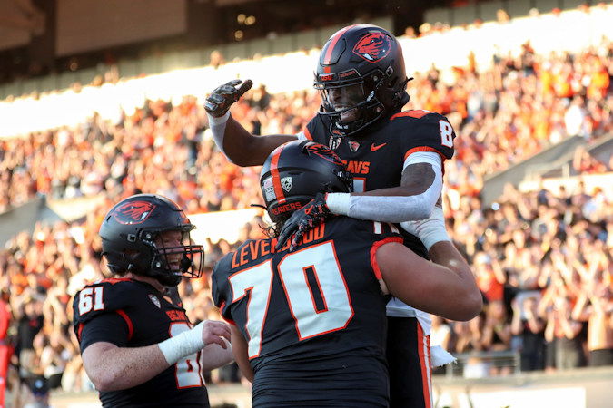 Oregon State wide receiver Rweha Munyagi Jr. (8) is lifted by offensive linemen Jake Levengood (70), next to Tanner Miller (61), as they celebrate Munyagi's touchdown against UC Davis during the first half of Saturday's game in Corvallis