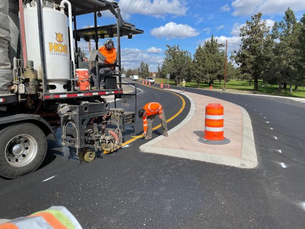 Crews install permanent pavement markings at the intersection of Deschutes Market and Hamehook roads
