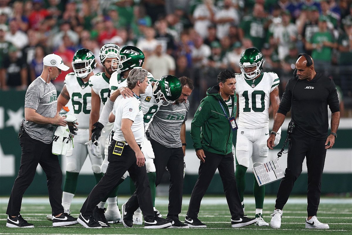 <i>Elsa/Getty Images</i><br/>Aaron Rodgers is helped off the field by team trainers after an injury during the first quarter of the New York Jets' game against the Buffalo Bills.
