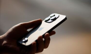 A man holds an iPhone 14 as Apple Inc's new models go on sale at an Apple store in Beijing