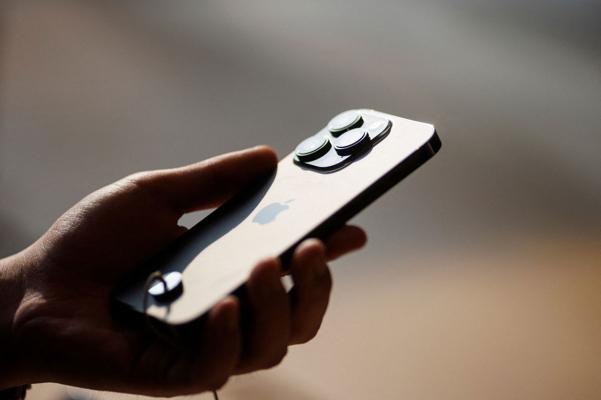 <i>Thomas Peter/Reuters</i><br/>A man holds an iPhone 14 as Apple Inc's new models go on sale at an Apple store in Beijing