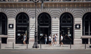 Customers exit an Apple Inc. store in the Opera district in Paris