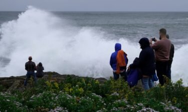 People watch rough surf and waves