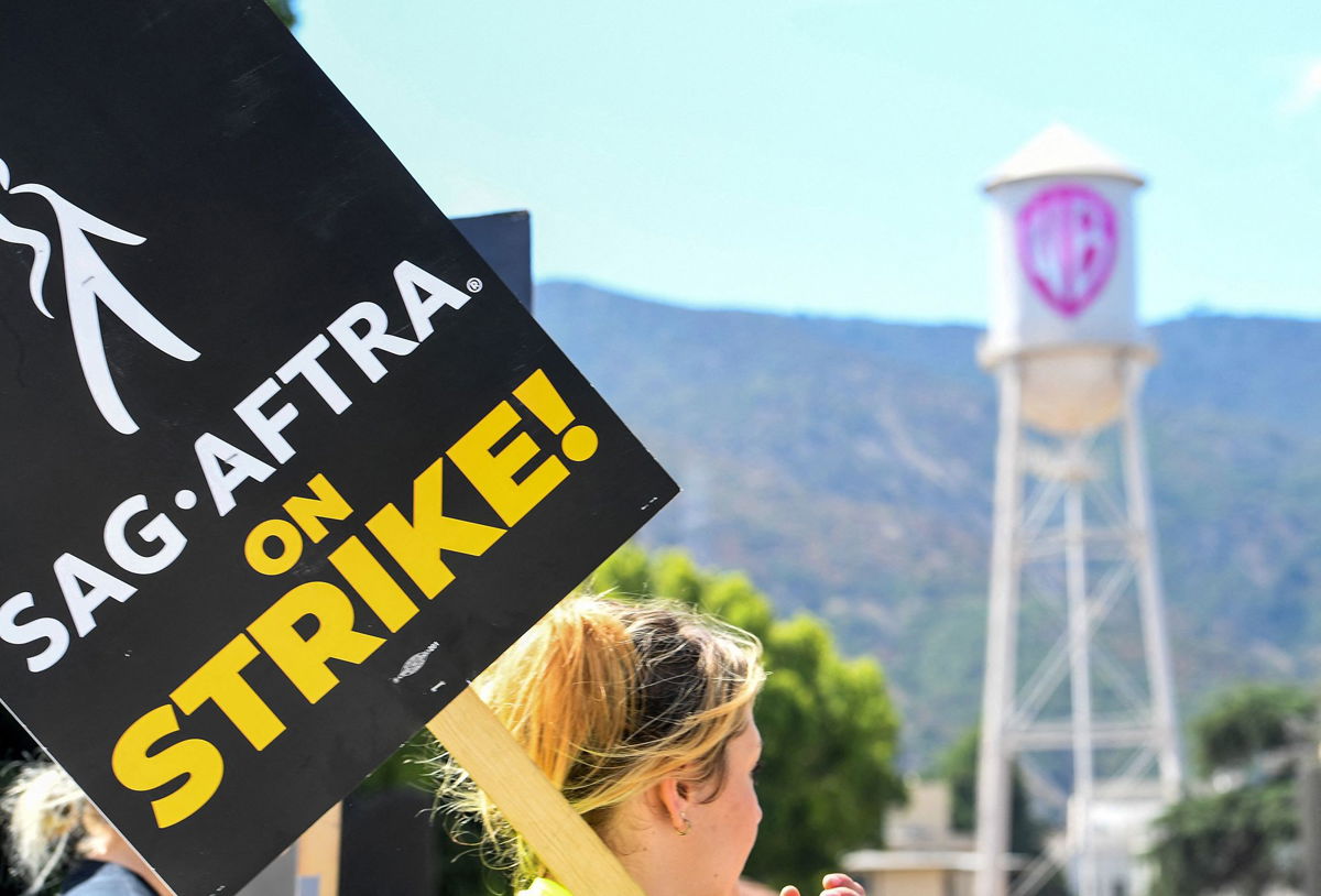 <i>Valerie Macon/AFP/Getty Images</i><br/>Members of the Writers Guild of America and the Screen Actors Guild walk a picket line outside of Warner Bros Studio in Burbank