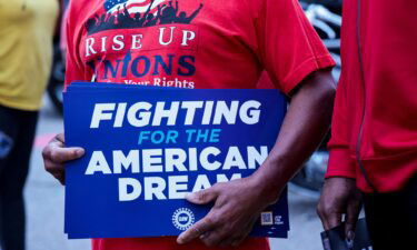 A United Auto Workers union member holds a sign outside Stellantis Sterling Heights Assembly Plant