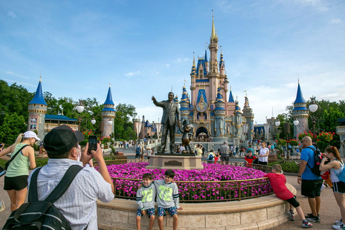 <i>Ted Shaffrey/AP</i><br/>People visit the Magic Kingdom Park at Walt Disney World Resort in Lake Buena Vista in April 2022. Disney has dropped part of its lawsuit against Florida Governor Ron DeSantis to focus on free speech claims.