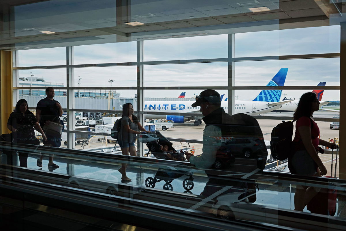 <i>Chip Somodevilla/Getty Images</i><br/>Passengers walk between terminals at Ronald Reagan Washington National Airport on August 8 in Arlington