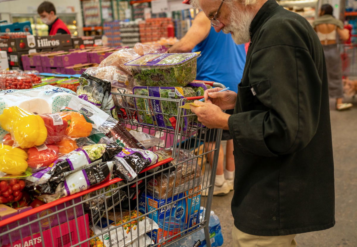 <i>Robert Nickelsberg/Getty Images</i><br/>A person goes through a note pad while shopping for items at a Costco Wholesale store on September 6 in Colchester