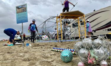 Attendees known as "burners" strike down their Unicorner camp before new rainfalls in a muddy desert plain on September 3